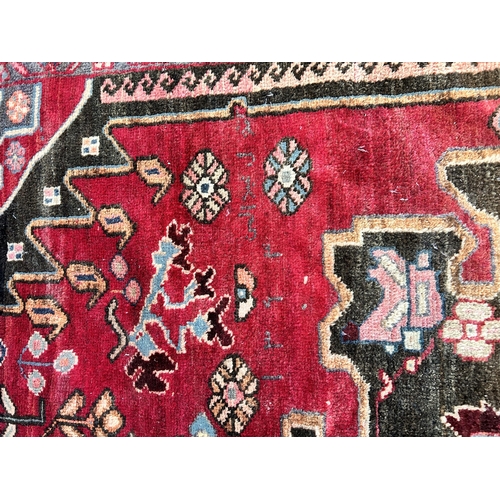 151C - A Persian hand knotted rug with signature - approx. 190cm x 166cm