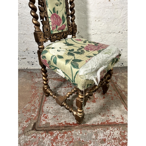 158 - A Victorian heavily carved and gilded occasional chair with floral upholstery