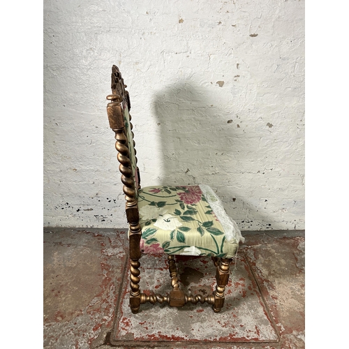 158 - A Victorian heavily carved and gilded occasional chair with floral upholstery