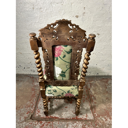 158 - A Victorian heavily carved and gilded occasional chair with floral upholstery