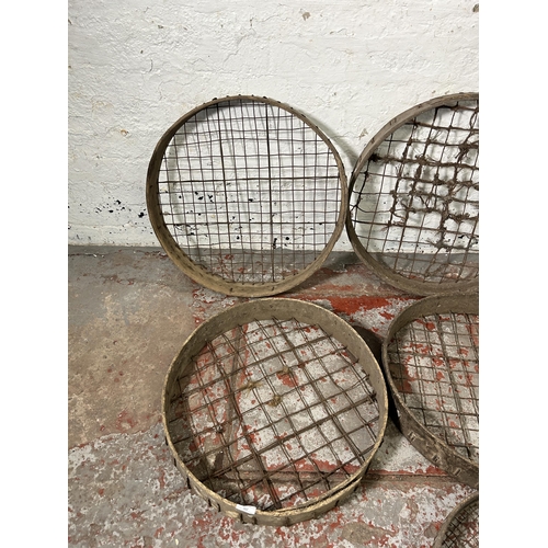 162 - Seven antique wooden and metal wired potato picking baskets - largest approx. 62cm high