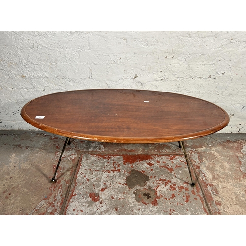 187 - A mid 20th century teak effect oval coffee table on hairpin supports - approx. 41cm high x 53cm wide... 