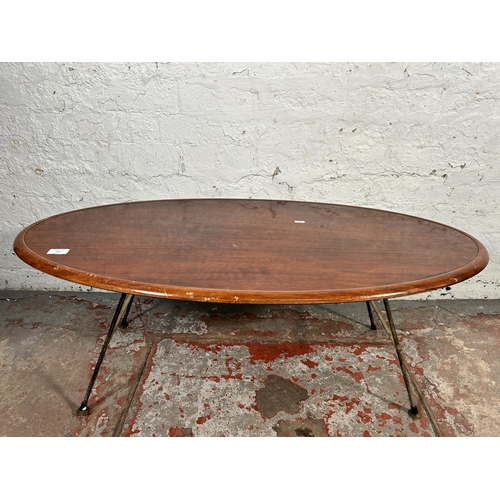 187 - A mid 20th century teak effect oval coffee table on hairpin supports - approx. 41cm high x 53cm wide... 