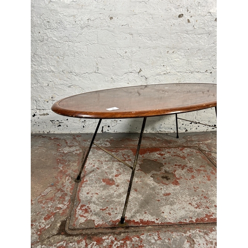 187 - A mid 20th century teak effect oval coffee table on hairpin supports - approx. 41cm high x 53cm wide... 