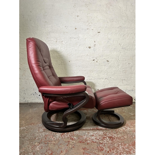 22 - A Himolla oxblood leather and bentwood swivel reclining armchair and footstool