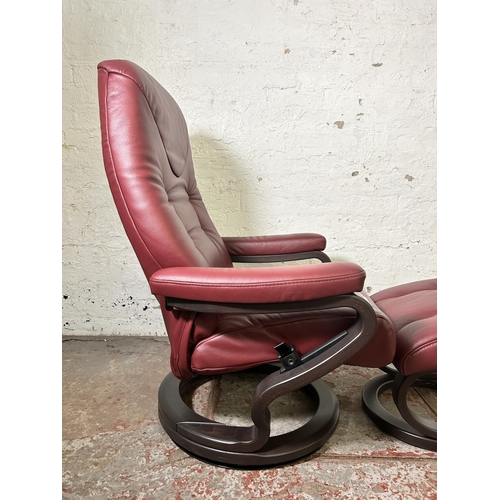 22 - A Himolla oxblood leather and bentwood swivel reclining armchair and footstool