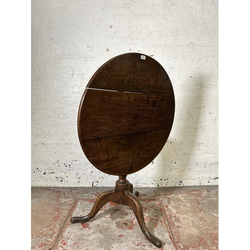 40 - A George III oak circular tilt top tripod occasional table - approx. 114cm high x 78cm in diameter