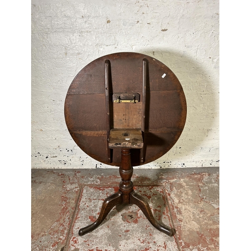 40 - A George III oak circular tilt top tripod occasional table - approx. 114cm high x 78cm in diameter