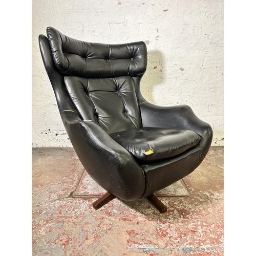 45 - A mid 20th century Parker Knoll Statesman black vinyl and teak swivel armchair