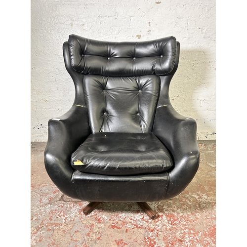 45 - A mid 20th century Parker Knoll Statesman black vinyl and teak swivel armchair