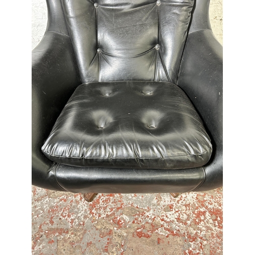 46 - A mid 20th century Parker Knoll Statesman black vinyl and teak swivel armchair