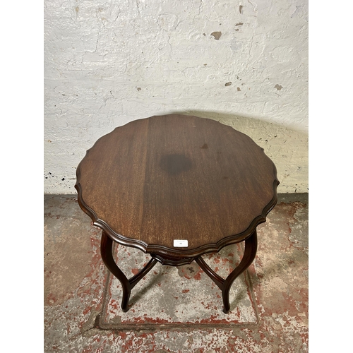 62 - An Edwardian mahogany serpentine two tier occasional table