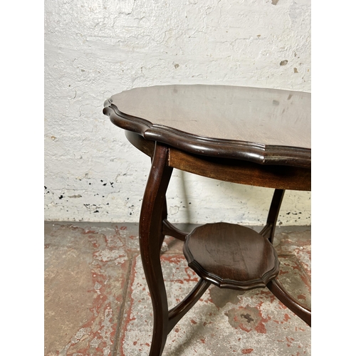 62 - An Edwardian mahogany serpentine two tier occasional table