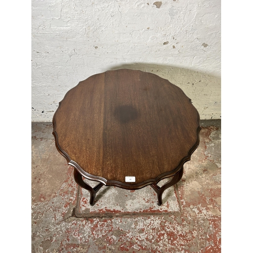 62 - An Edwardian mahogany serpentine two tier occasional table