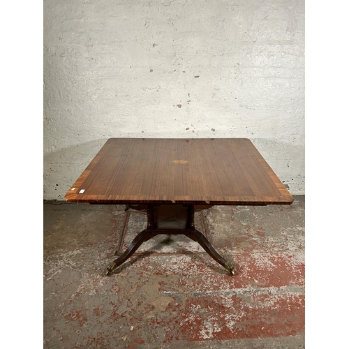 86 - An early 20th century Georgian style inlaid mahogany dining table on quatrefoil base and brass lion ... 