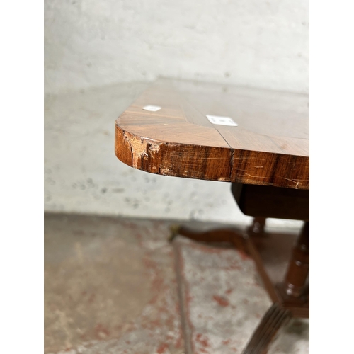 86 - An early 20th century Georgian style inlaid mahogany dining table on quatrefoil base and brass lion ... 