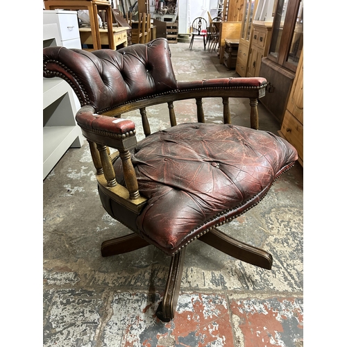 93 - An oxblood leather and mahogany captain's swivel desk chair