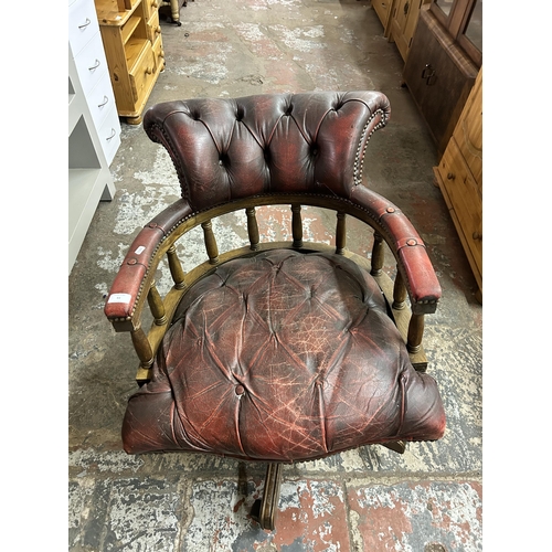 93 - An oxblood leather and mahogany captain's swivel desk chair