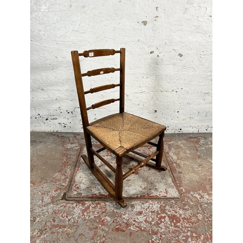 195 - A 19th century ash and elm rush seated ladder back rocking chair