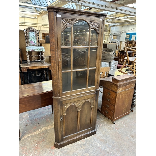 203 - A carved oak free standing corner cabinet