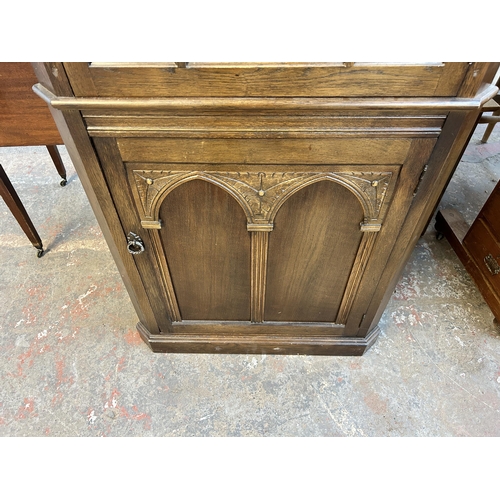 203 - A carved oak free standing corner cabinet