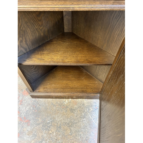 203 - A carved oak free standing corner cabinet