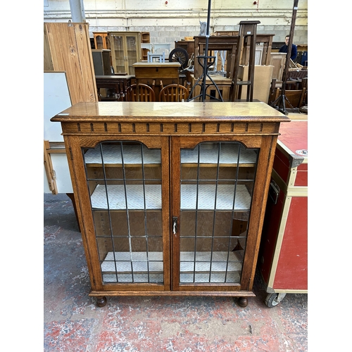 209 - An early 20th century oak display cabinet with two lead glazed doors