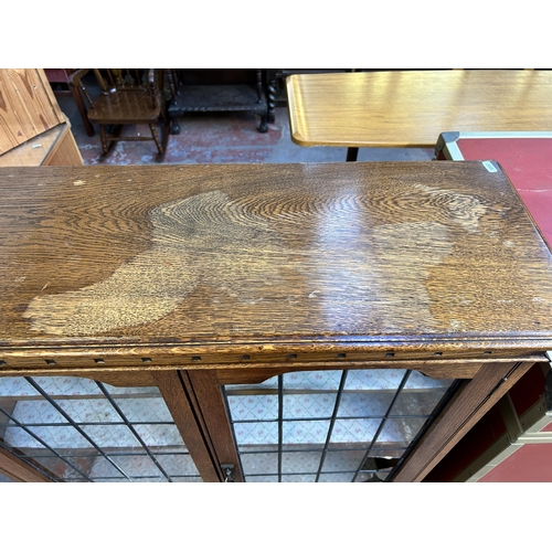 209 - An early 20th century oak display cabinet with two lead glazed doors