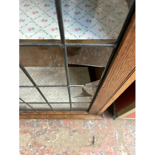 209 - An early 20th century oak display cabinet with two lead glazed doors