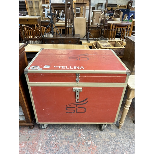 211 - A red painted and metal banded storage trunk on castors - approx. 92cm high x 101cm wide x 66cm deep