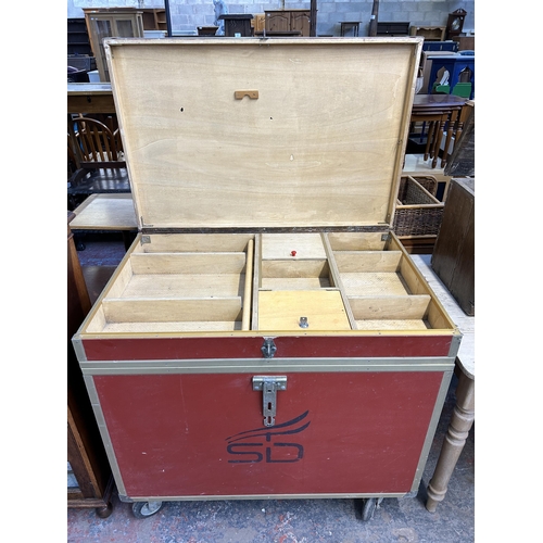 211 - A red painted and metal banded storage trunk on castors - approx. 92cm high x 101cm wide x 66cm deep