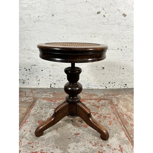 214 - A late 19th/early 20th century beech and cane adjustable piano stool - approx. 50cm high x 39cm in d... 