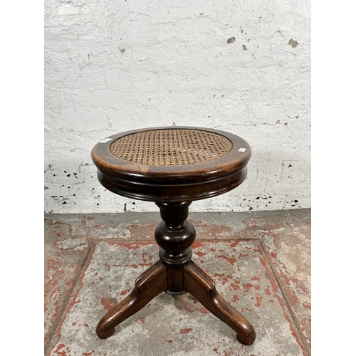 214 - A late 19th/early 20th century beech and cane adjustable piano stool - approx. 50cm high x 39cm in d... 