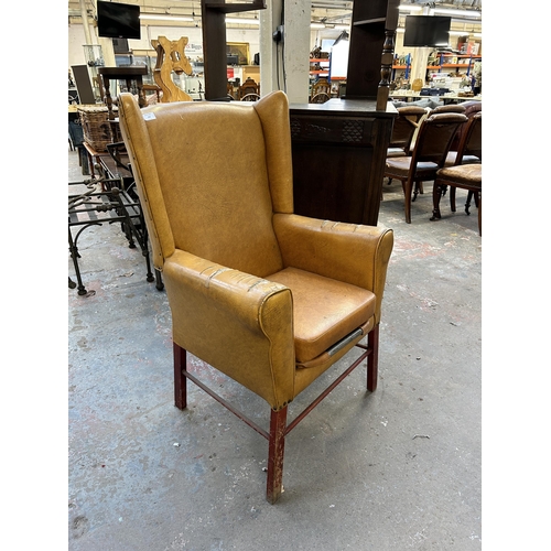 234 - A mid 20th century mustard yellow vinyl upholstered wingback armchair