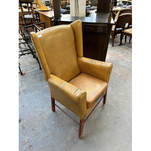 234 - A mid 20th century mustard yellow vinyl upholstered wingback armchair