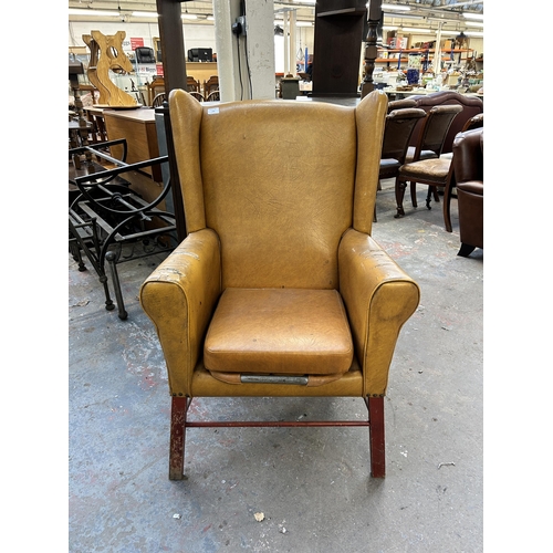 234 - A mid 20th century mustard yellow vinyl upholstered wingback armchair