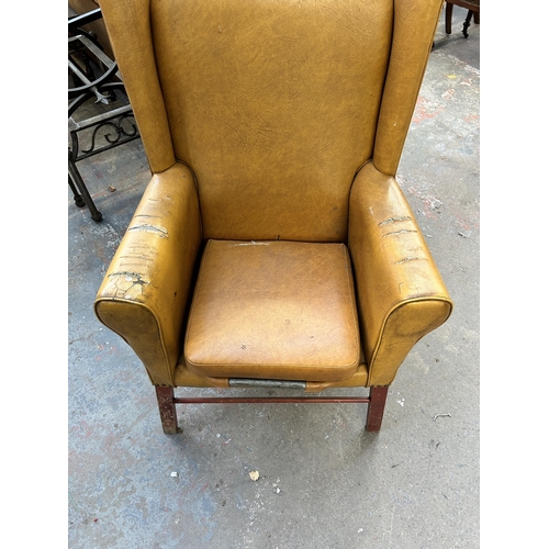 234 - A mid 20th century mustard yellow vinyl upholstered wingback armchair