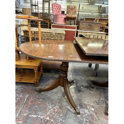 241 - A Regency style mahogany twin pedestal extending dining table on brass lion paw supports and casters