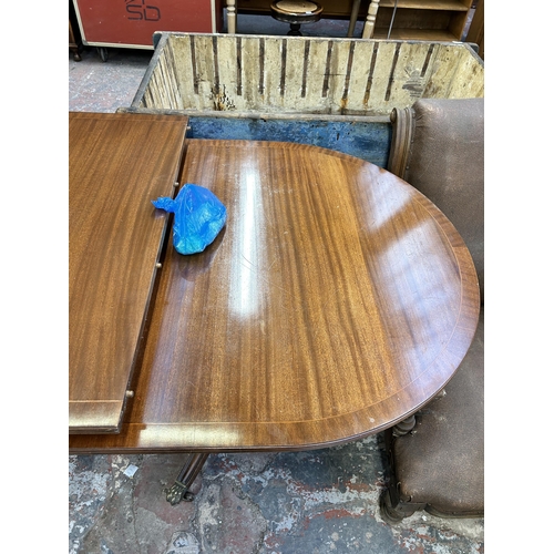 241 - A Regency style mahogany twin pedestal extending dining table on brass lion paw supports and casters