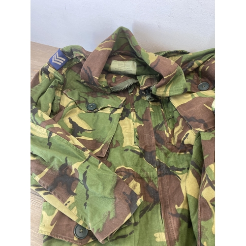 551 - Four pieces of military woodland camo clothing, two pairs of trousers, one shirt and one Smok combat... 