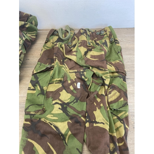 551 - Four pieces of military woodland camo clothing, two pairs of trousers, one shirt and one Smok combat... 