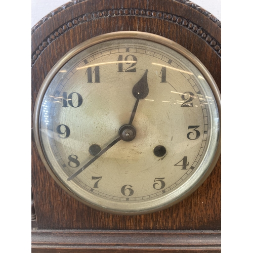 621 - An Art Deco oak cased chiming mantel clock with key and pendulum