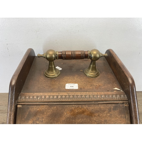 634 - An early 20th century oak and brass handled lidded coal scuttle