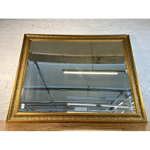 263 - A gilt framed bevelled edge wall mirror - approx. 91cm high x 117cm wide