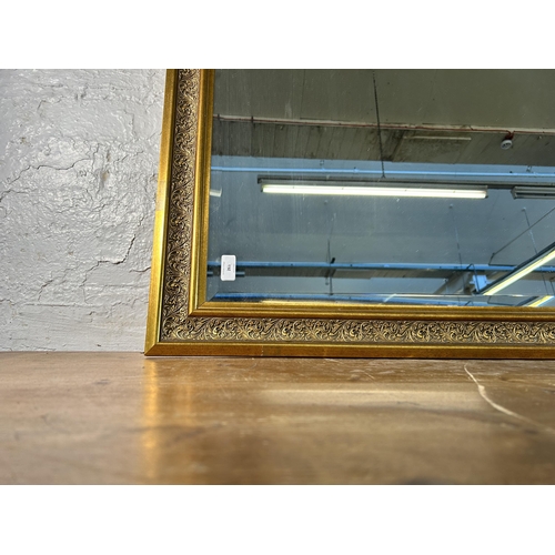 263 - A gilt framed bevelled edge wall mirror - approx. 91cm high x 117cm wide