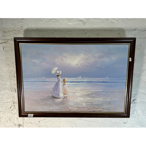 267 - A 20th century mahogany framed oil on canvas of a lady and girl on beach signed lower right - approx... 