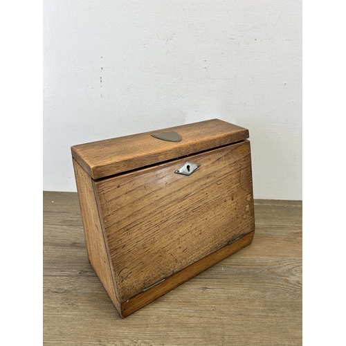 653 - An early 20th century oak full front letter rack with brass escutcheon and leather internals