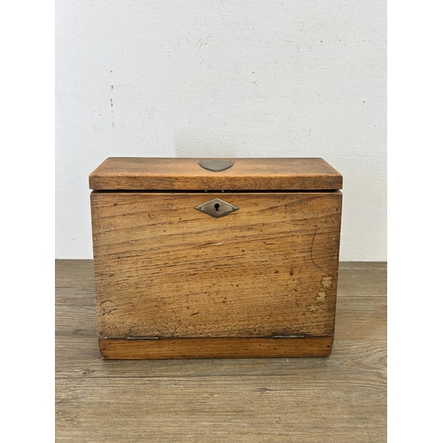 653 - An early 20th century oak full front letter rack with brass escutcheon and leather internals