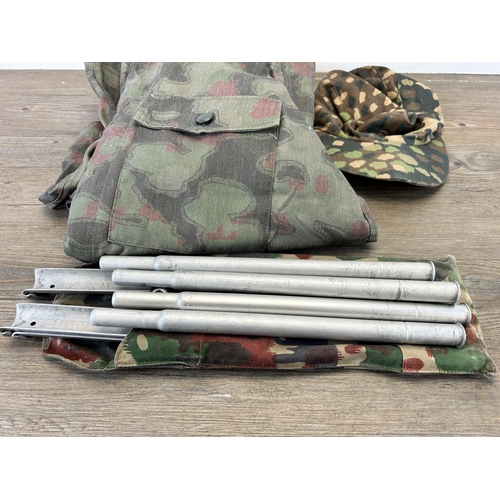 663 - Three pieces of reproduction WWII German militaria, bagged set of shelter poles, size L overalls and... 