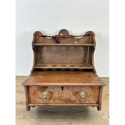 672 - An early 20th century mahogany wall mountable smoker's cabinet with five pipe holders and single dra... 